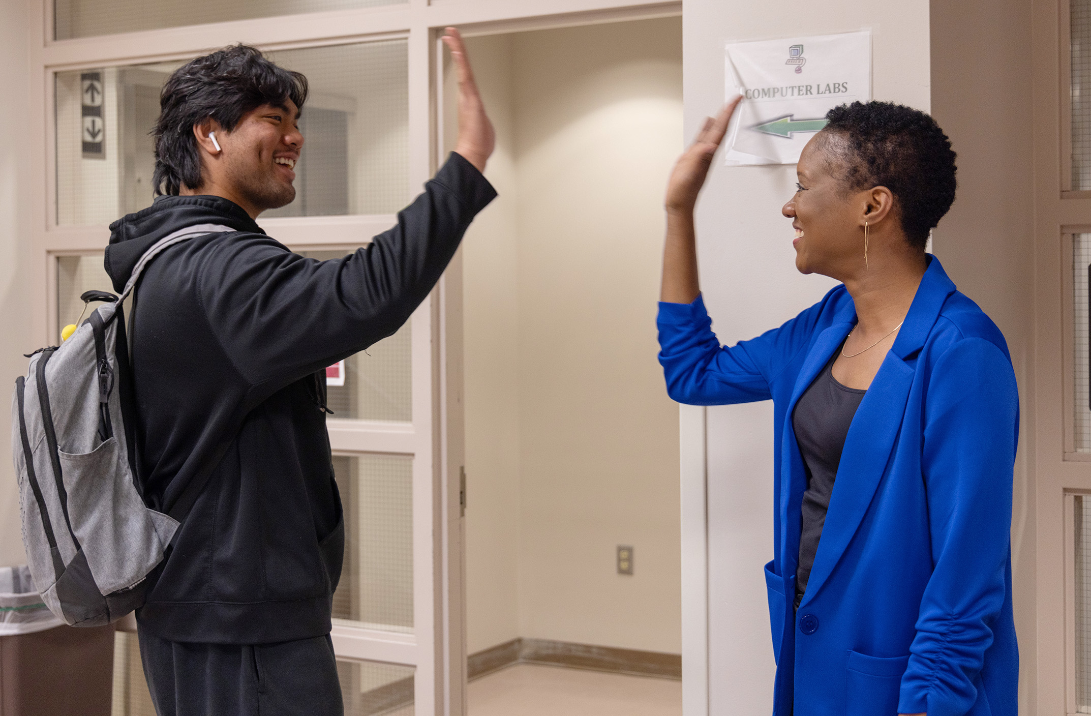 Photo of Tennecia Dacass high-fiveing a student