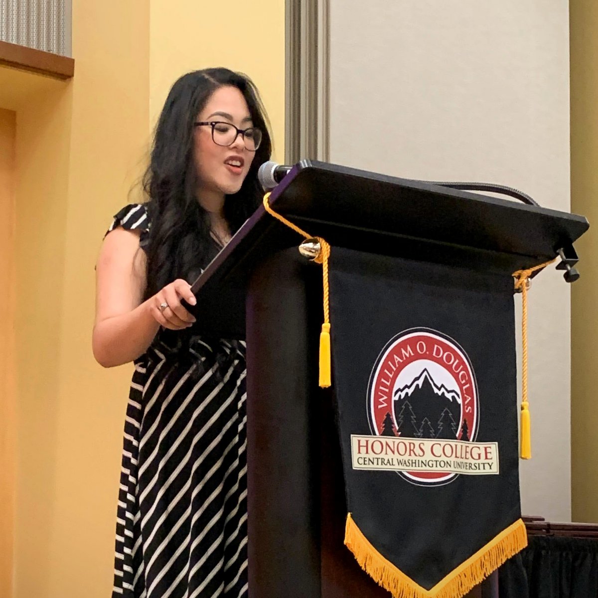 Monique Khim speaking at a podium for Douglas Honors.