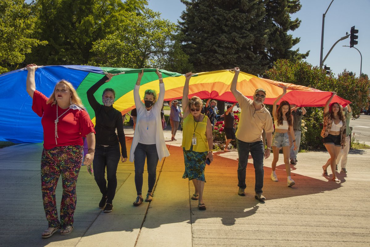 Students and faculty marching with a Pride flag