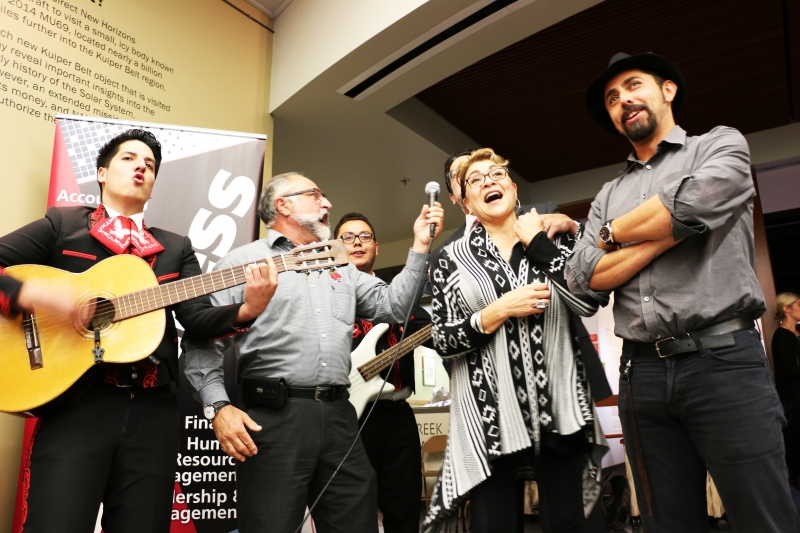 Latinx alumni performing music at a barbeque event