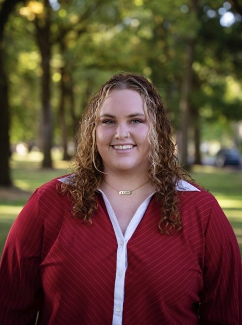 Jordan Spradlin Headshot. She is in front of a landscape background.