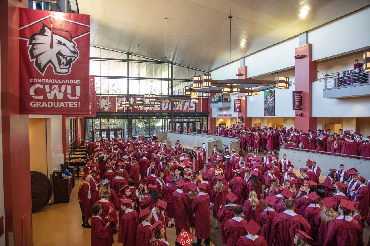 Large gathering of Students in their crimson cap and gowns, gathered in the SURC mess hall