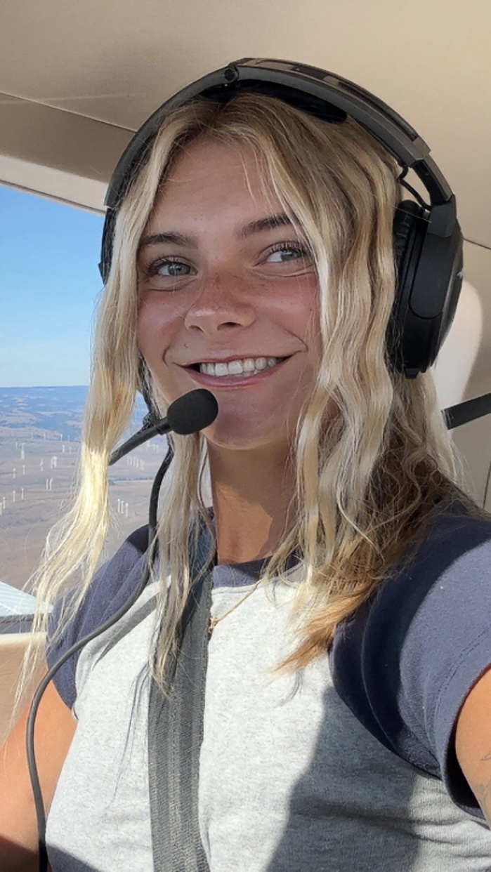 Aviation tutor in a grey shirt inside an airplane.