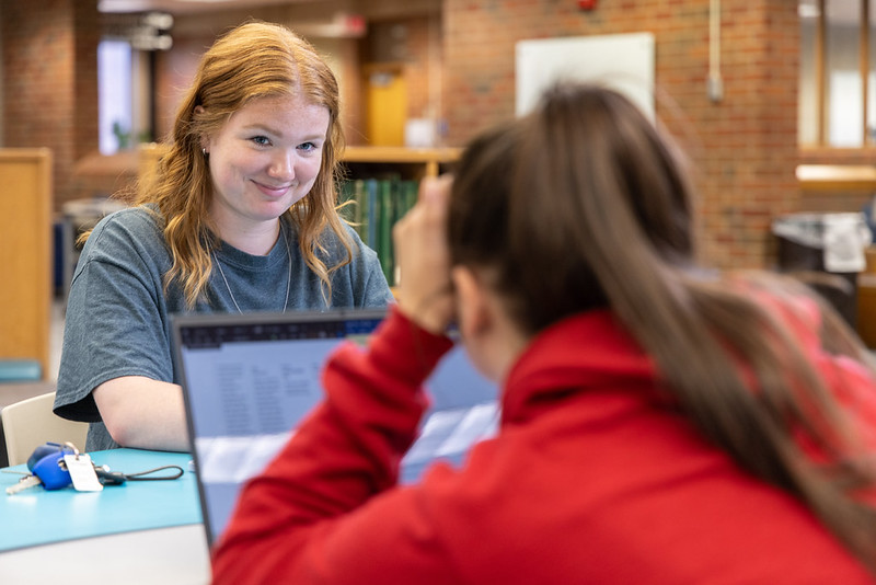 Students inside the library, communicating together
