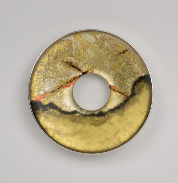 round metal jewelry piece with a hole in the center. 