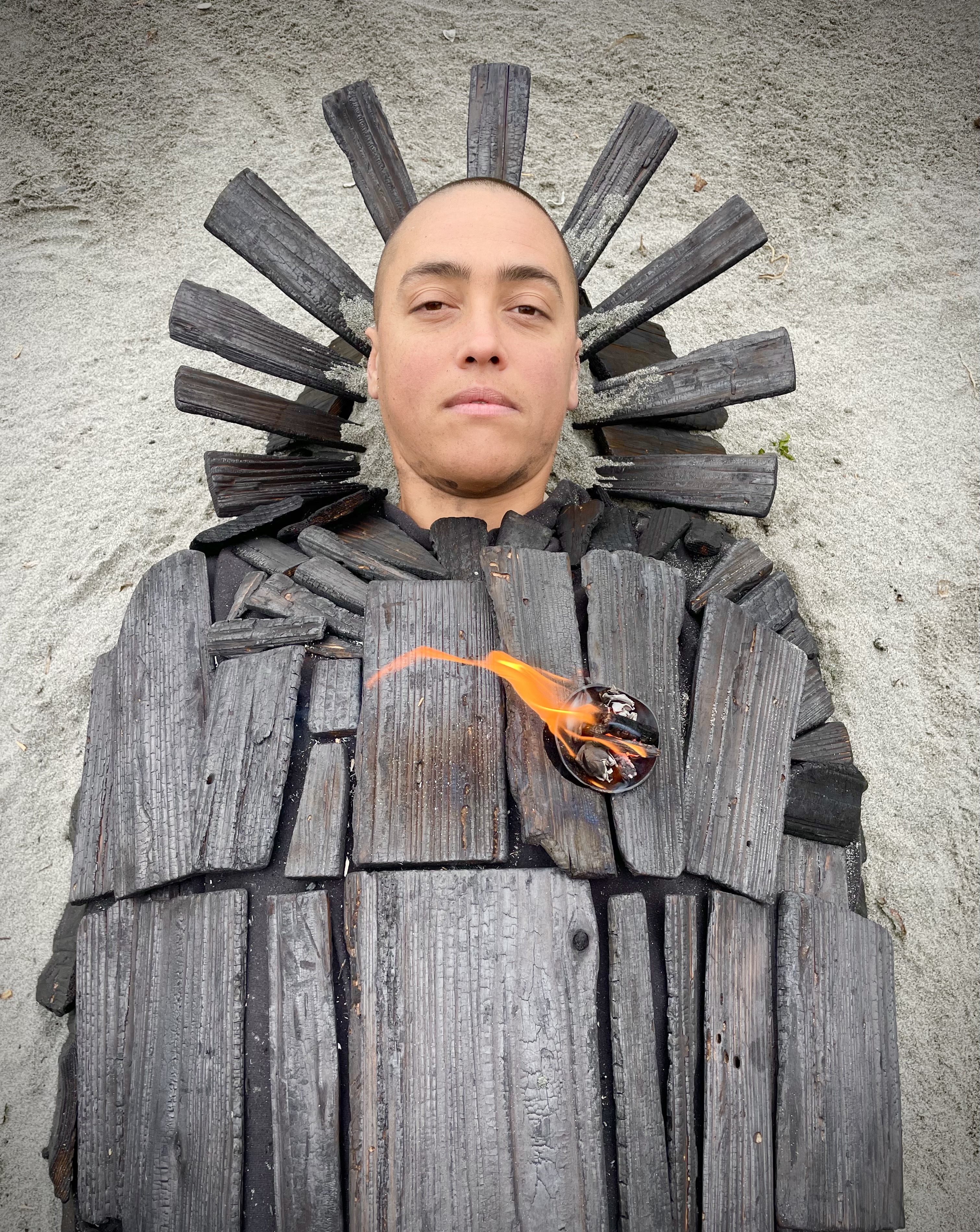 Image of a person lyiing down and encased in cedar wood panels.