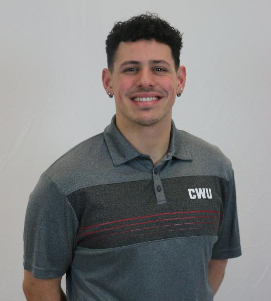 young man with black curly hair in grey CWU polo shirt