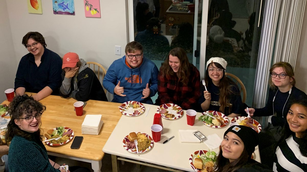 CWU students at a table eating and smiling.