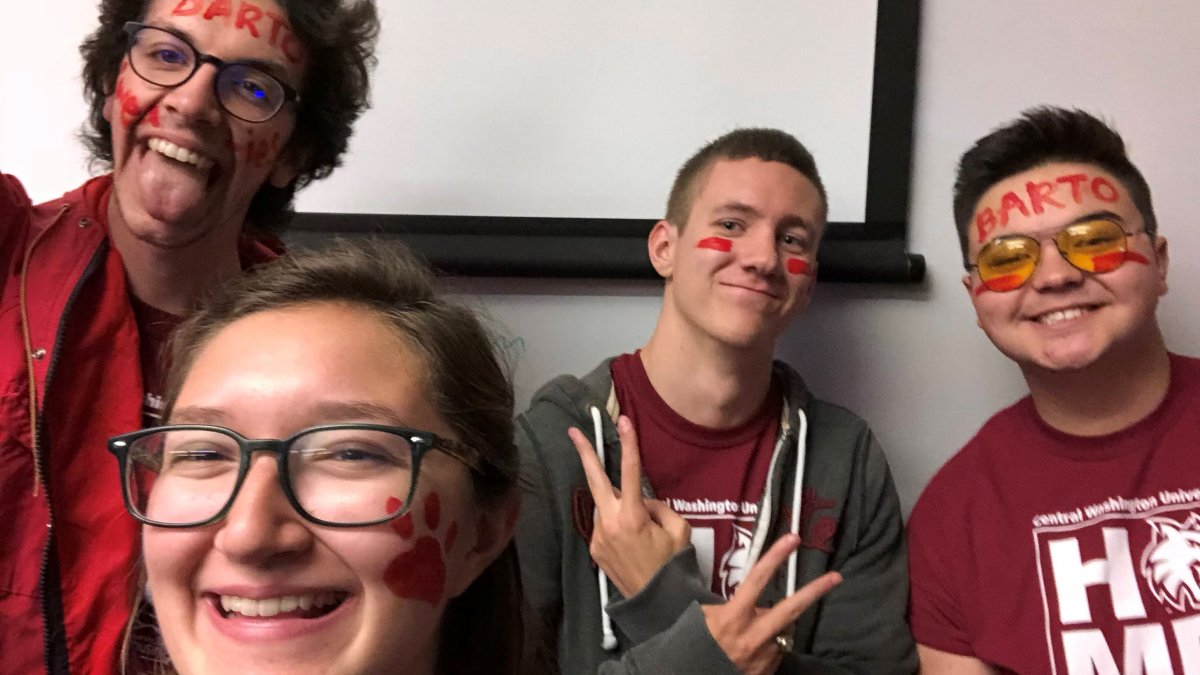 Four students posing in CWU facepaint.