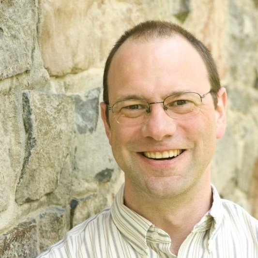 Headshot of Aaron Montgomery next to a stone wall.