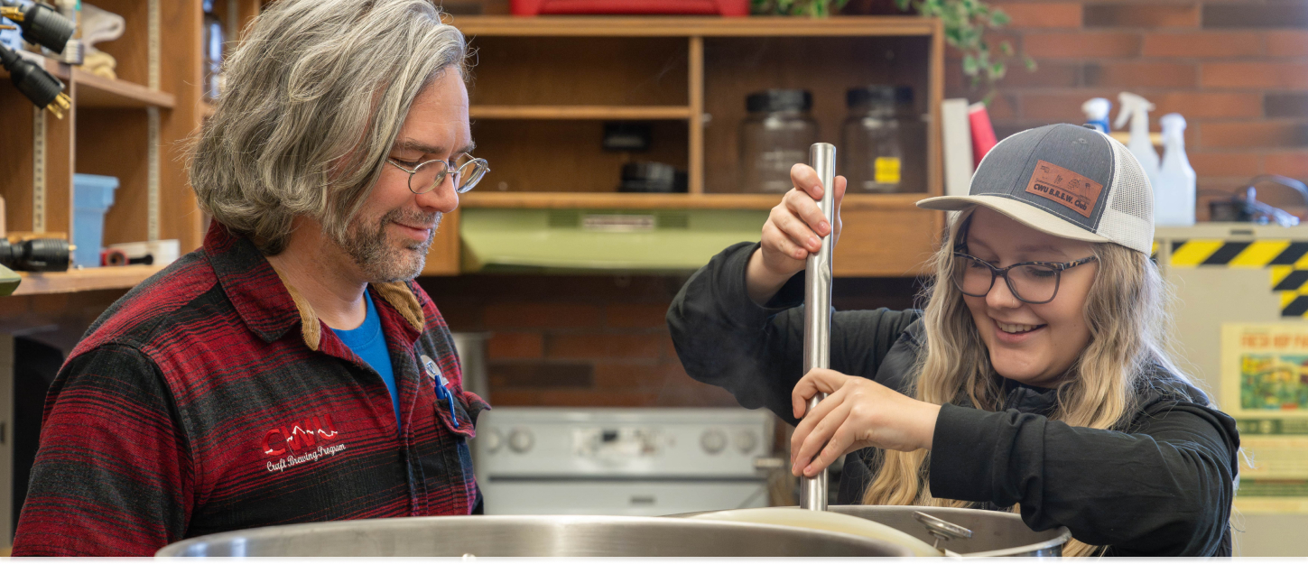 Student and professor stirring a pot during the brewing process