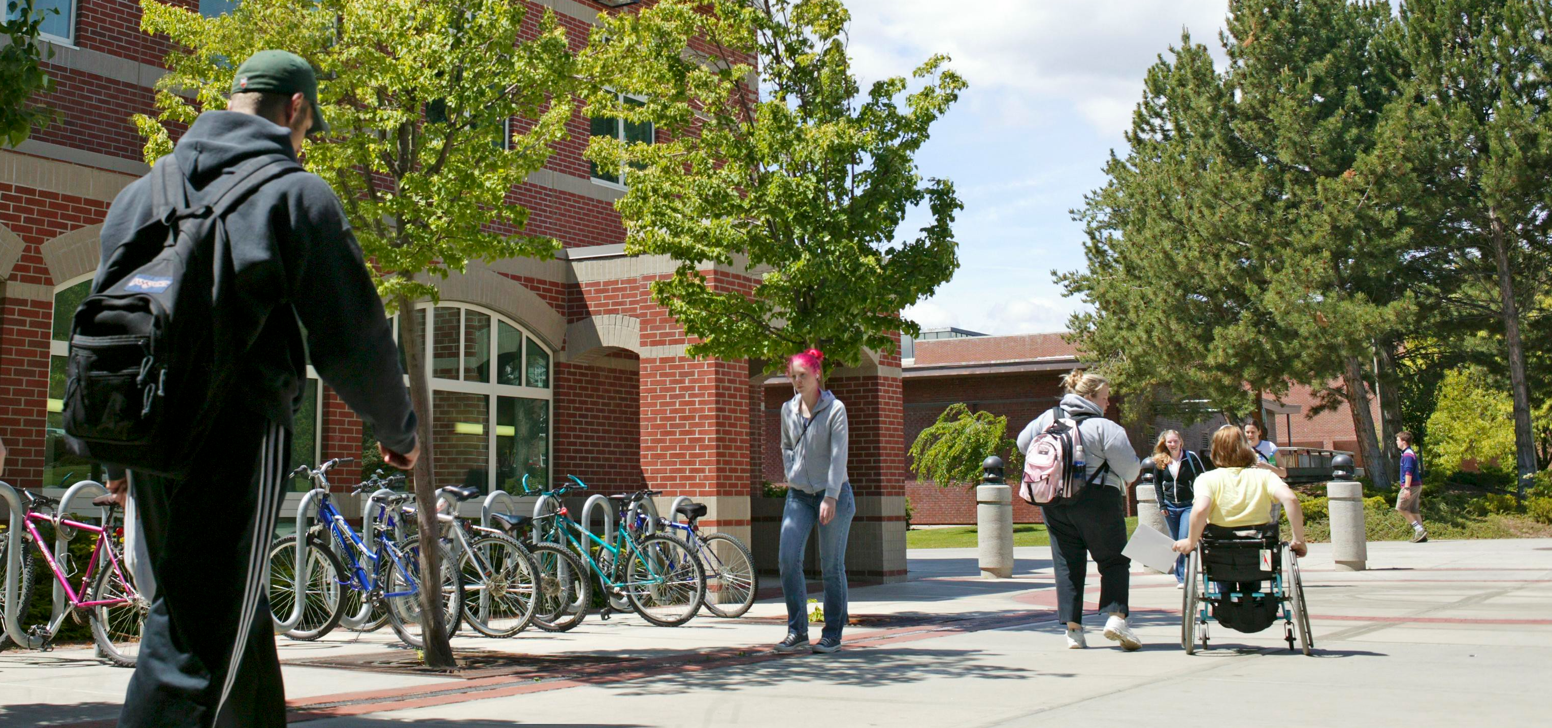 A student using a wheelchair and friend leaving Black Hall.