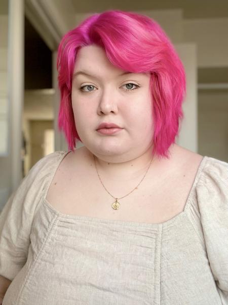 Photo of Juliana Kropla with a pink bob and wearing a square-neck blouse.
