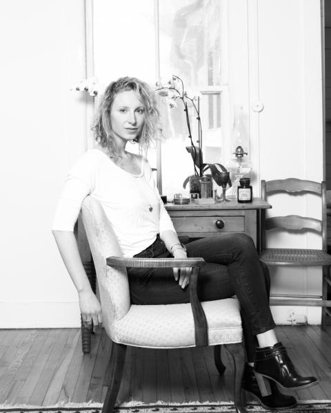 Portrait of Annie Dewitt in black and white sitting in a chair with her arm draped behind it