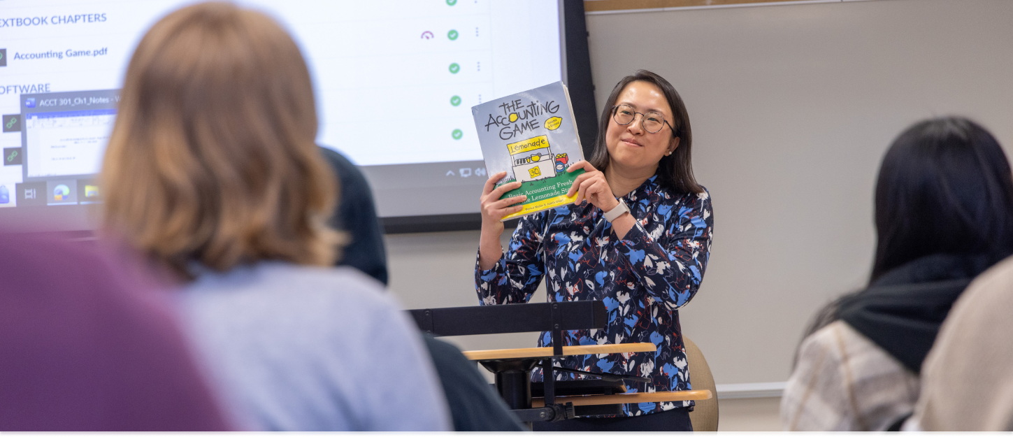 Professor holding up a book during class