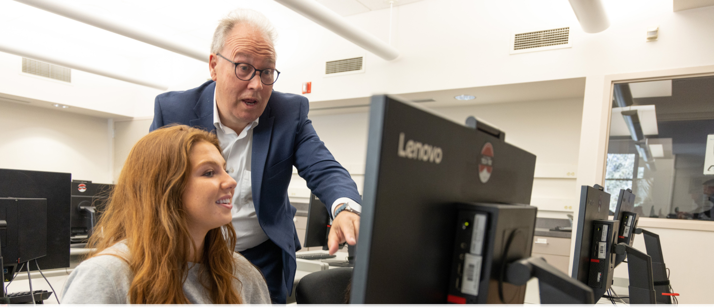 Professor pointing to computer screen.