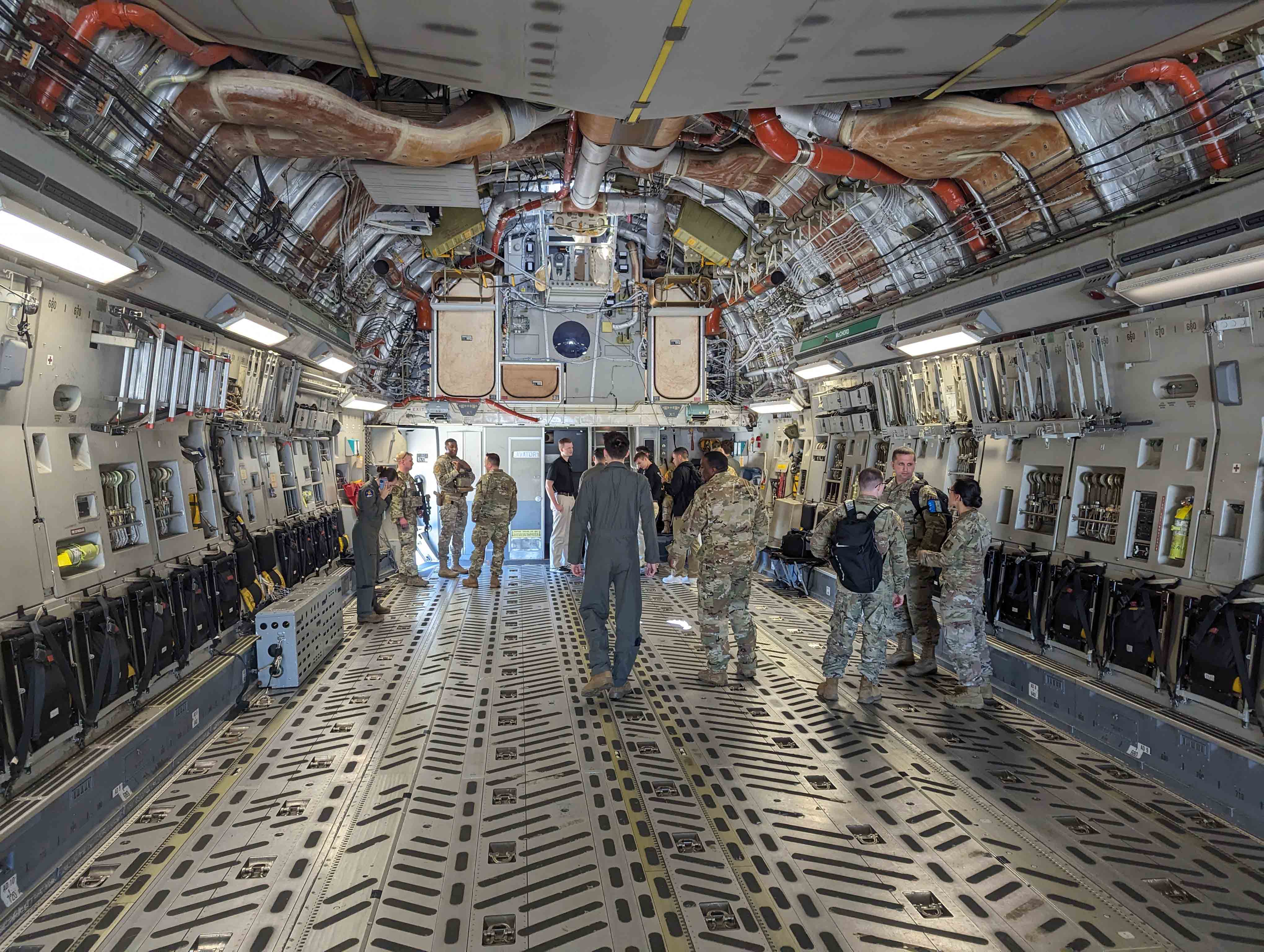 Students walking around the inside of a giant airplane used in the military