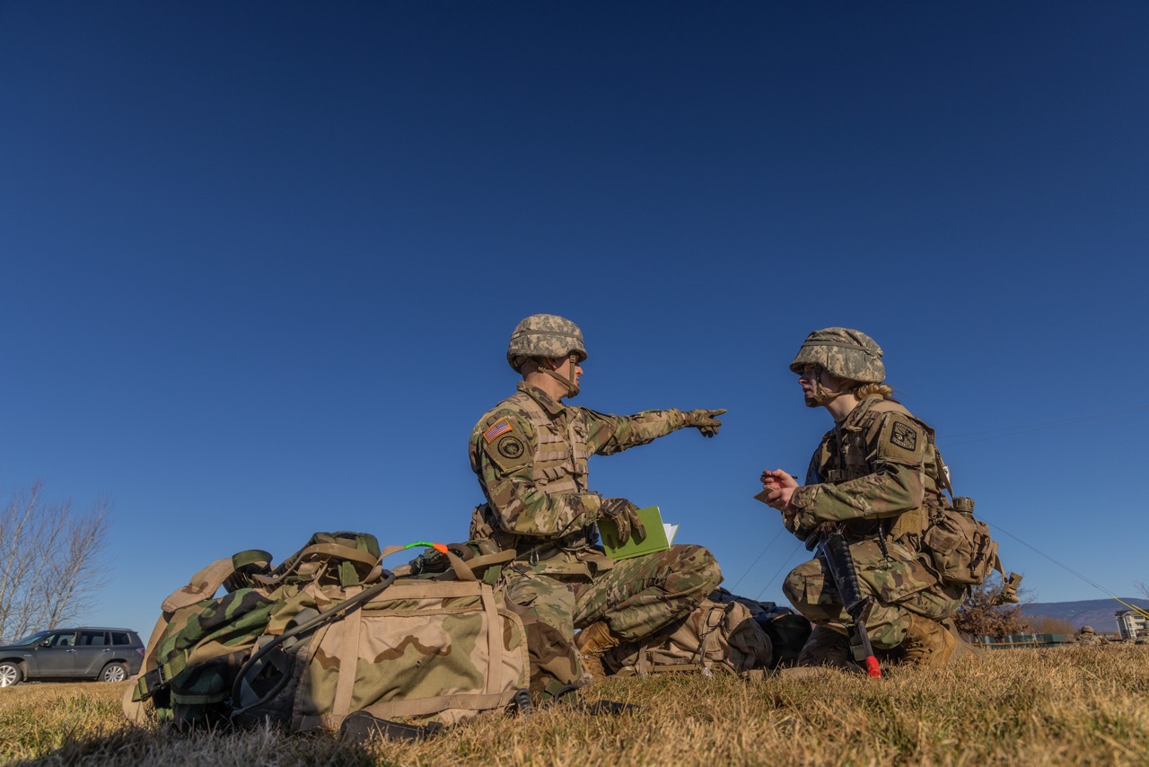 Two cadets pointing in the distance as if making a plan to move forward.