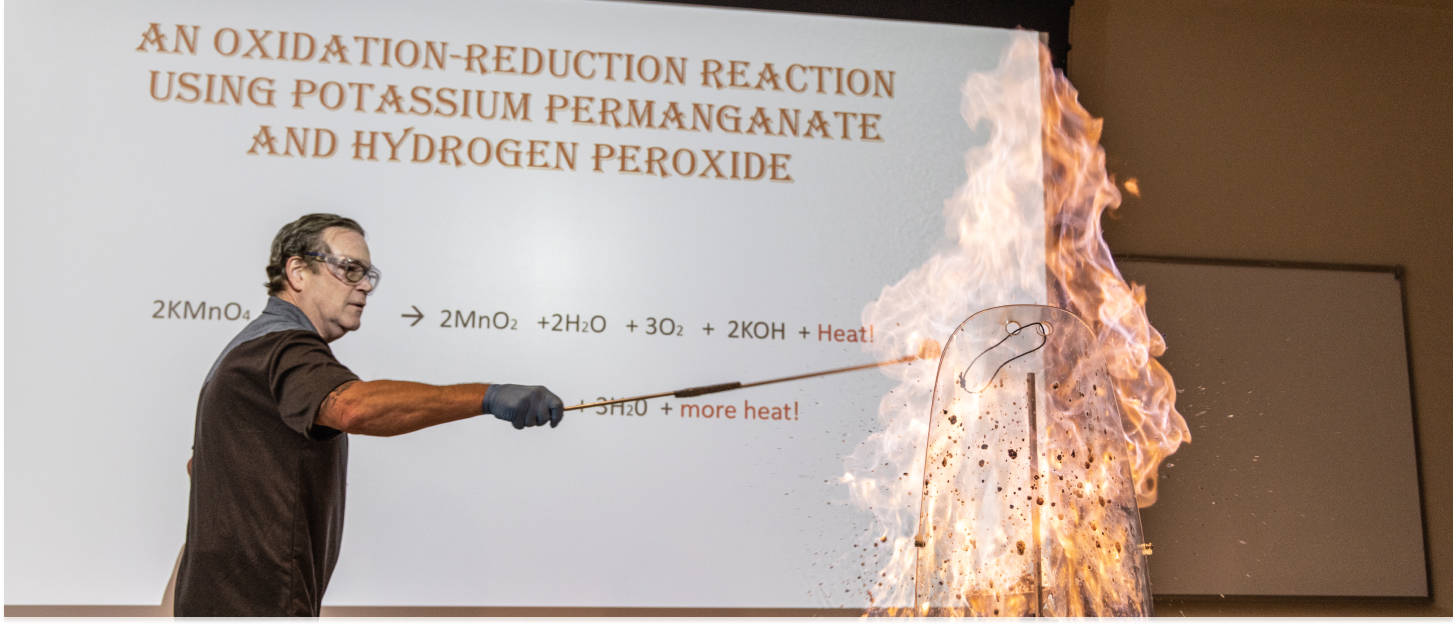 Professor doing a science experiment with a huge flame and a bubble