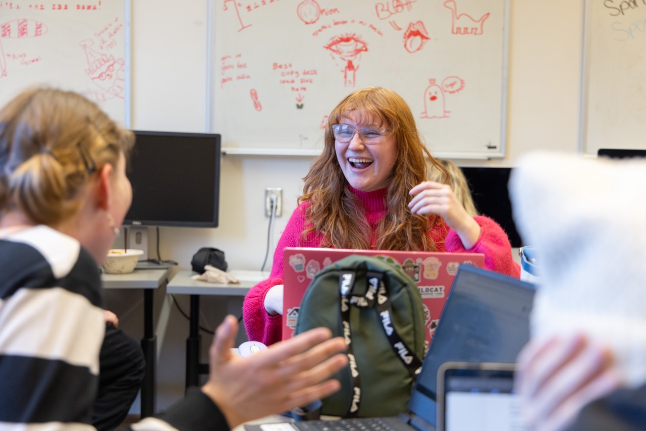 Student laughing with another student during class