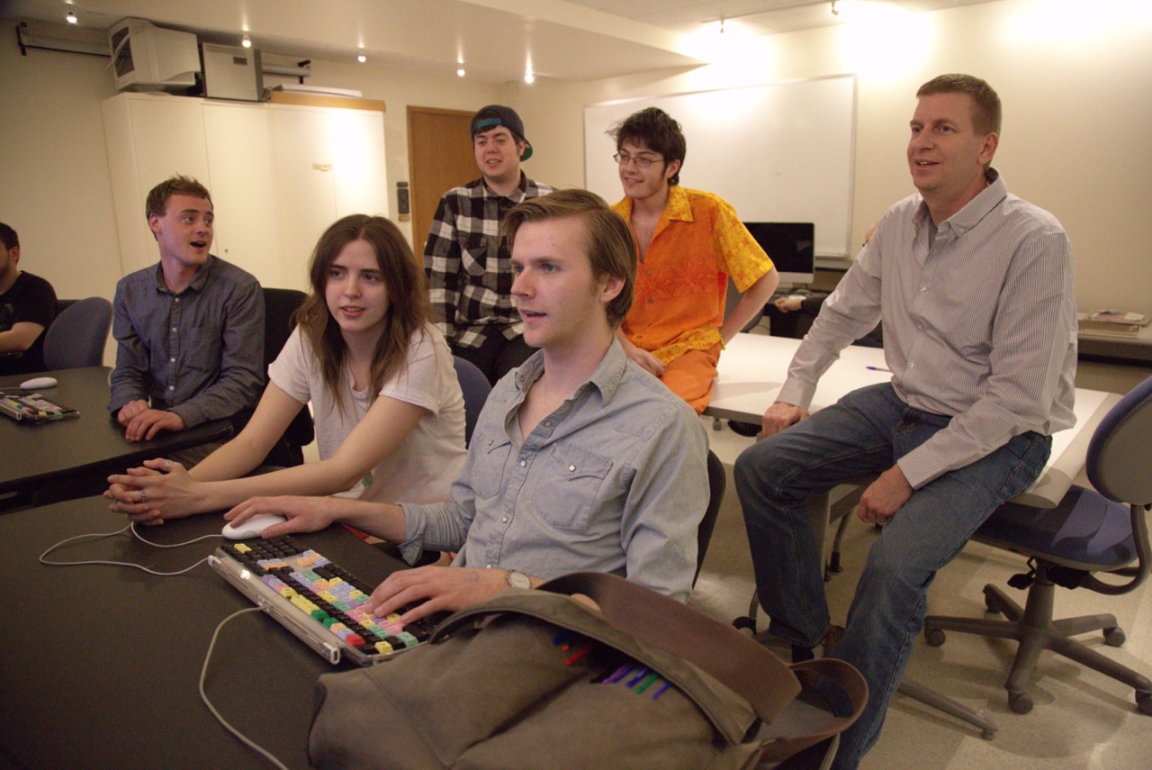 Group of students working with a faculty member on a computer