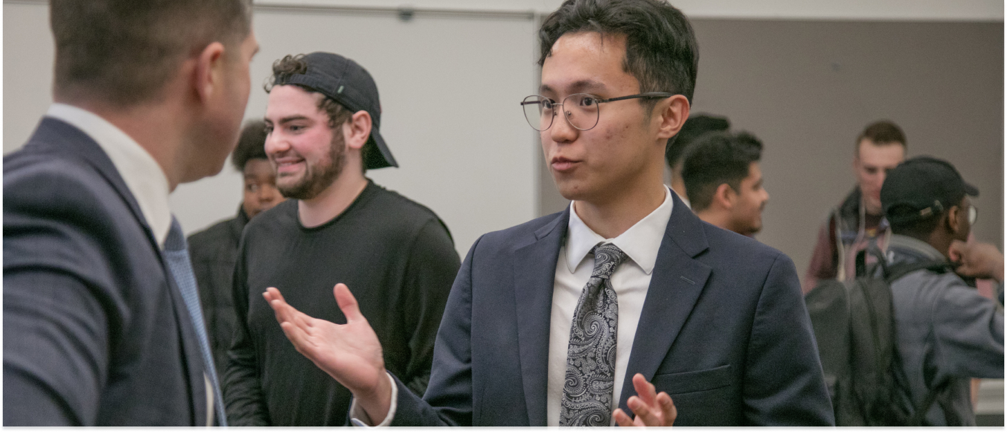 Student having a discussion in a business suit during an economics event at CWU.