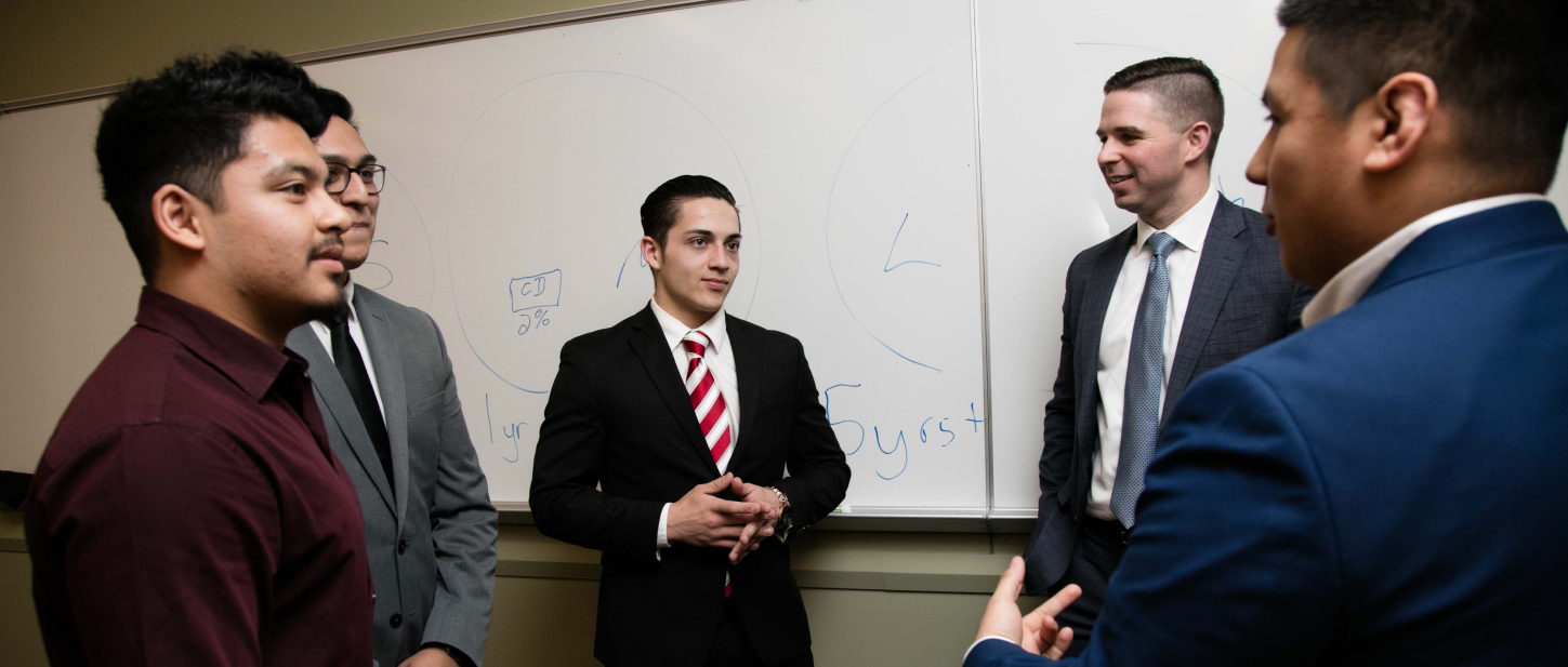 Students connecting on a project in front of a white board.