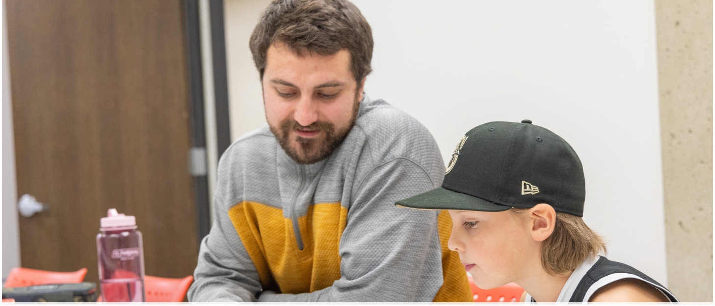 CWU student helping a younger student learn to read