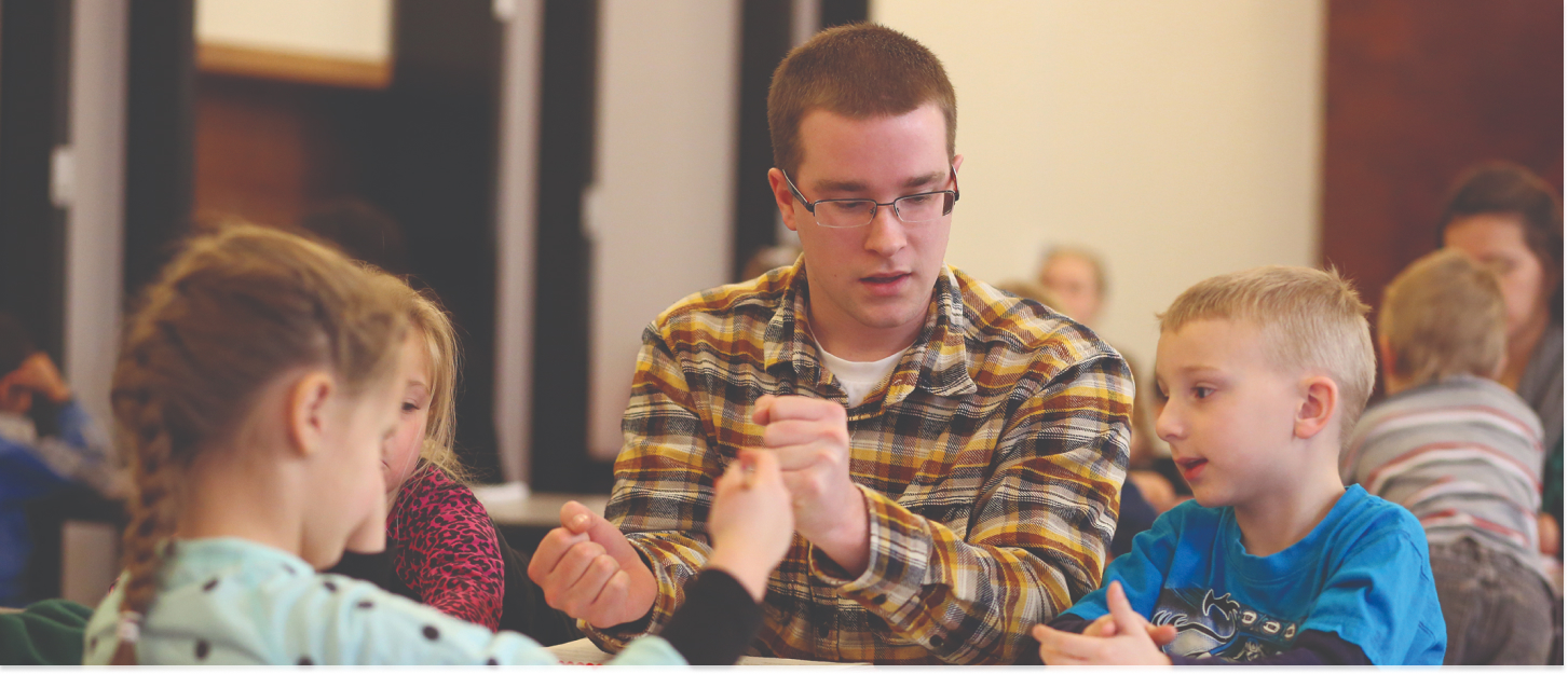 Student working with multiple children on a education project