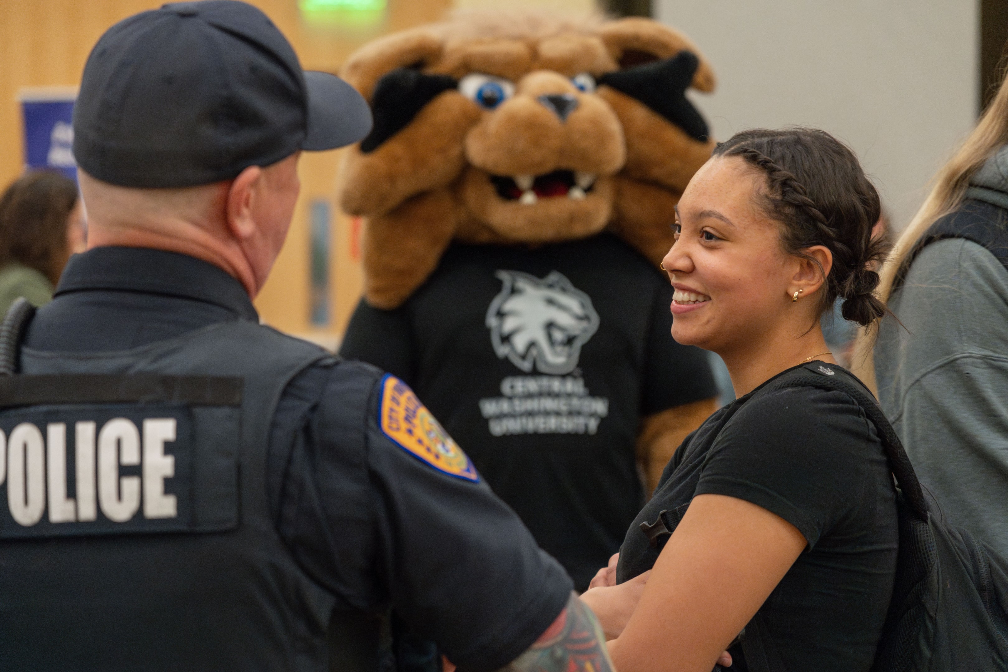 Student chatting with a police officer during a career fair.