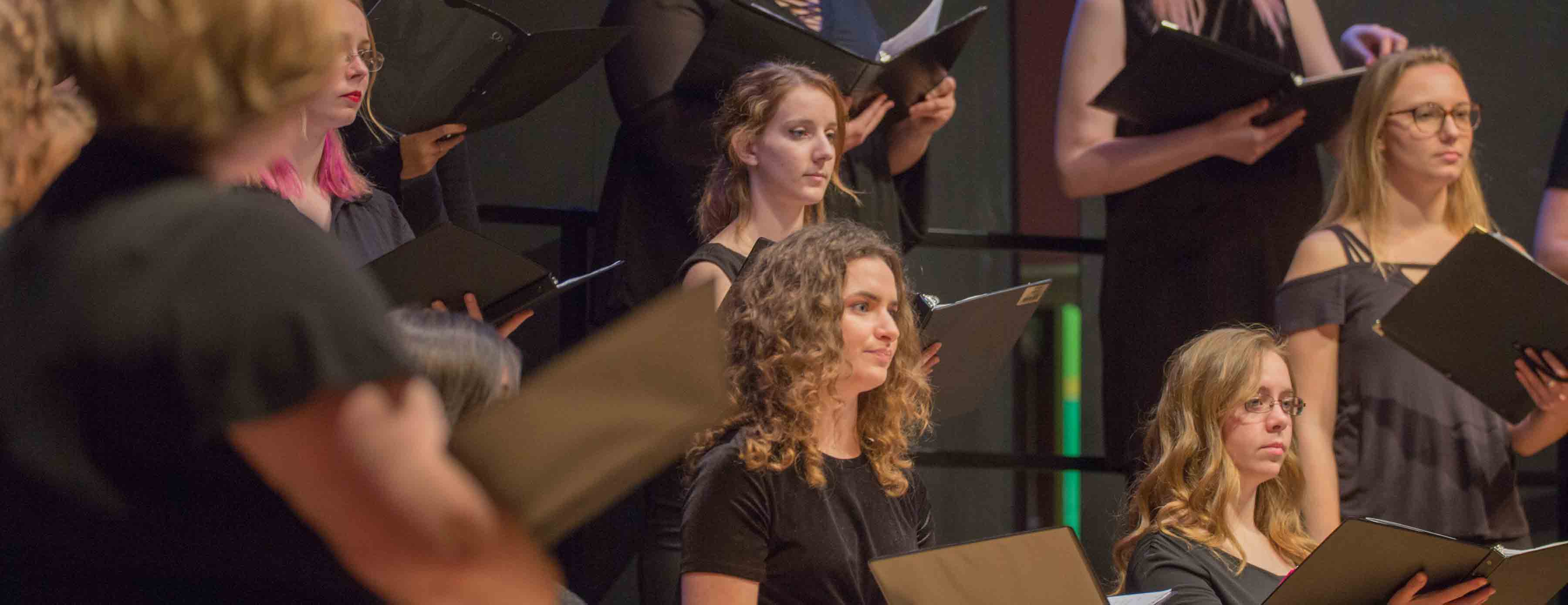 choire members holding folders with lyrics