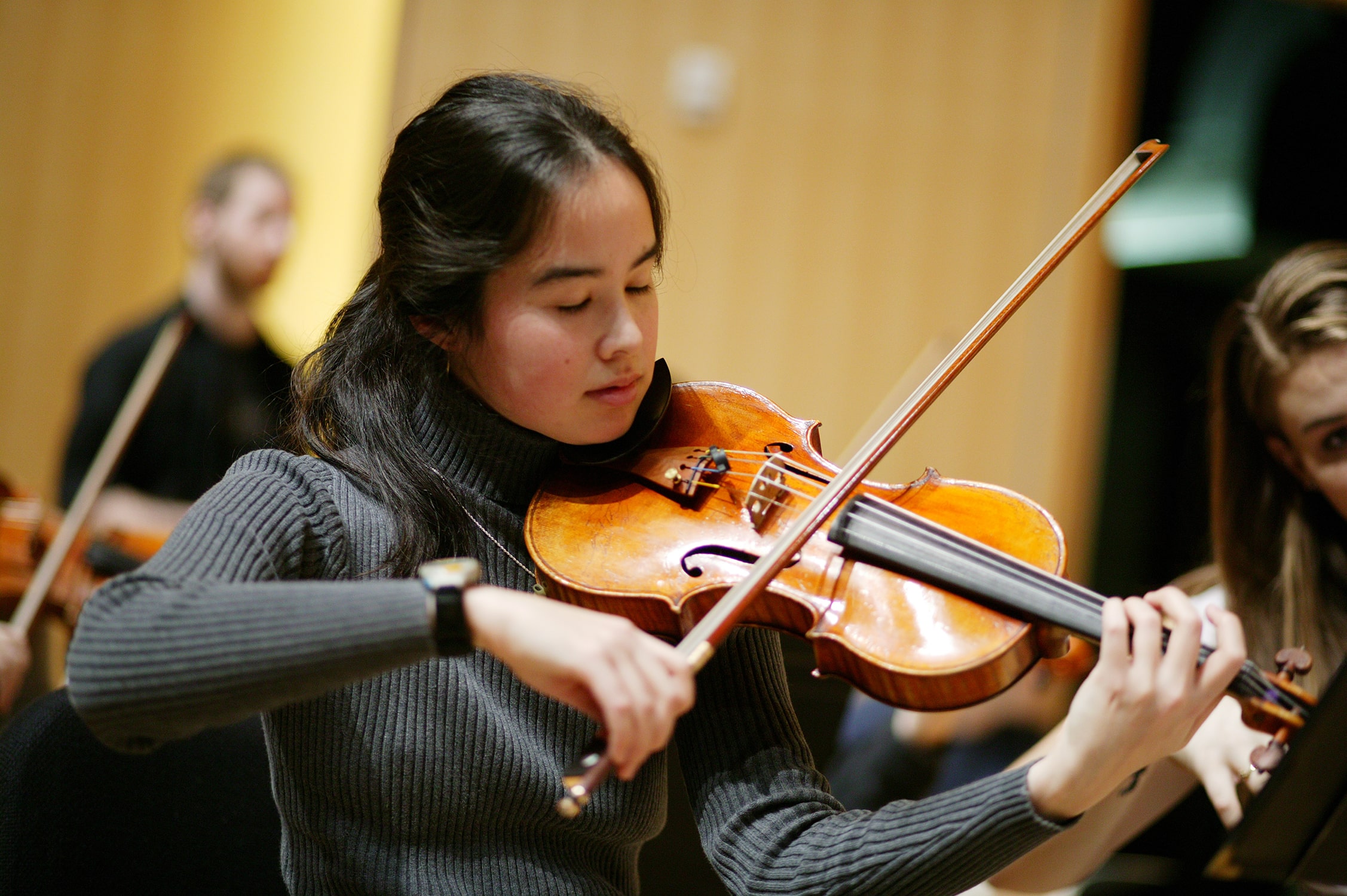 Student closing their eyes about the play the violin