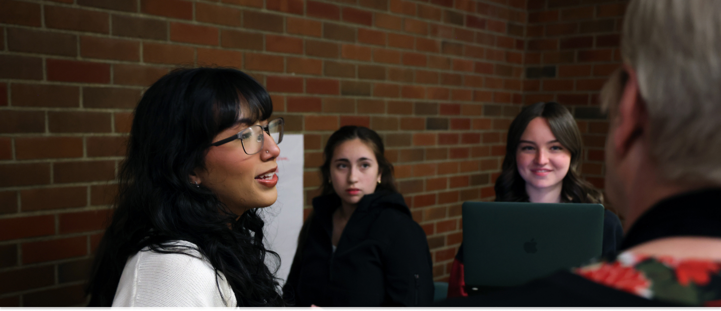 Three students presenting a project in class