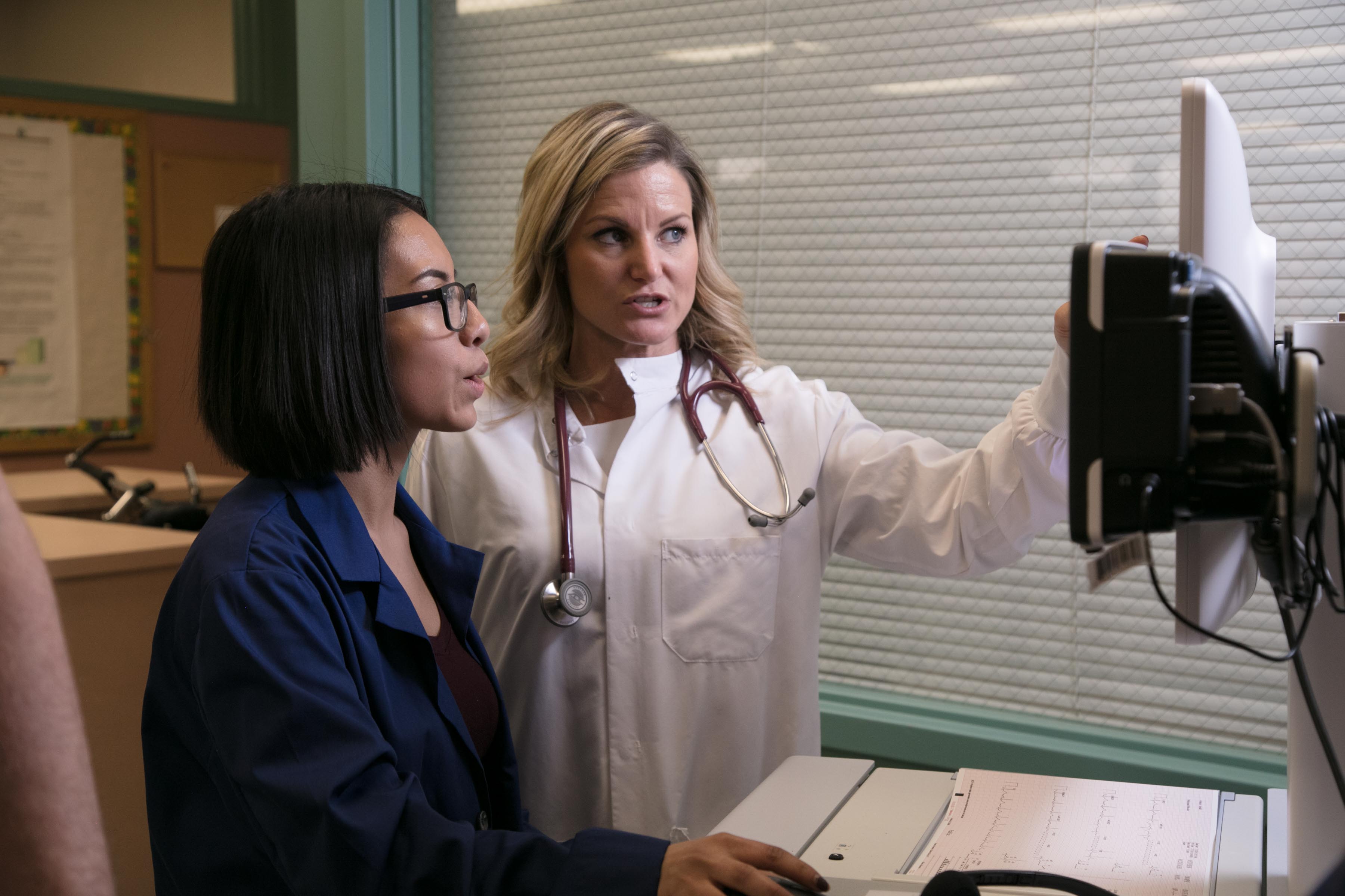 Two healthcare workers looking at a monitor