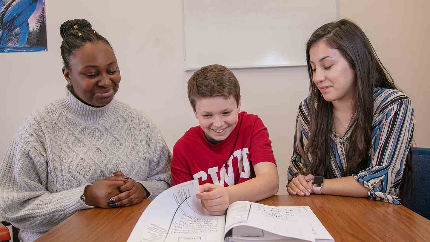 mentors help an excited kid with homework