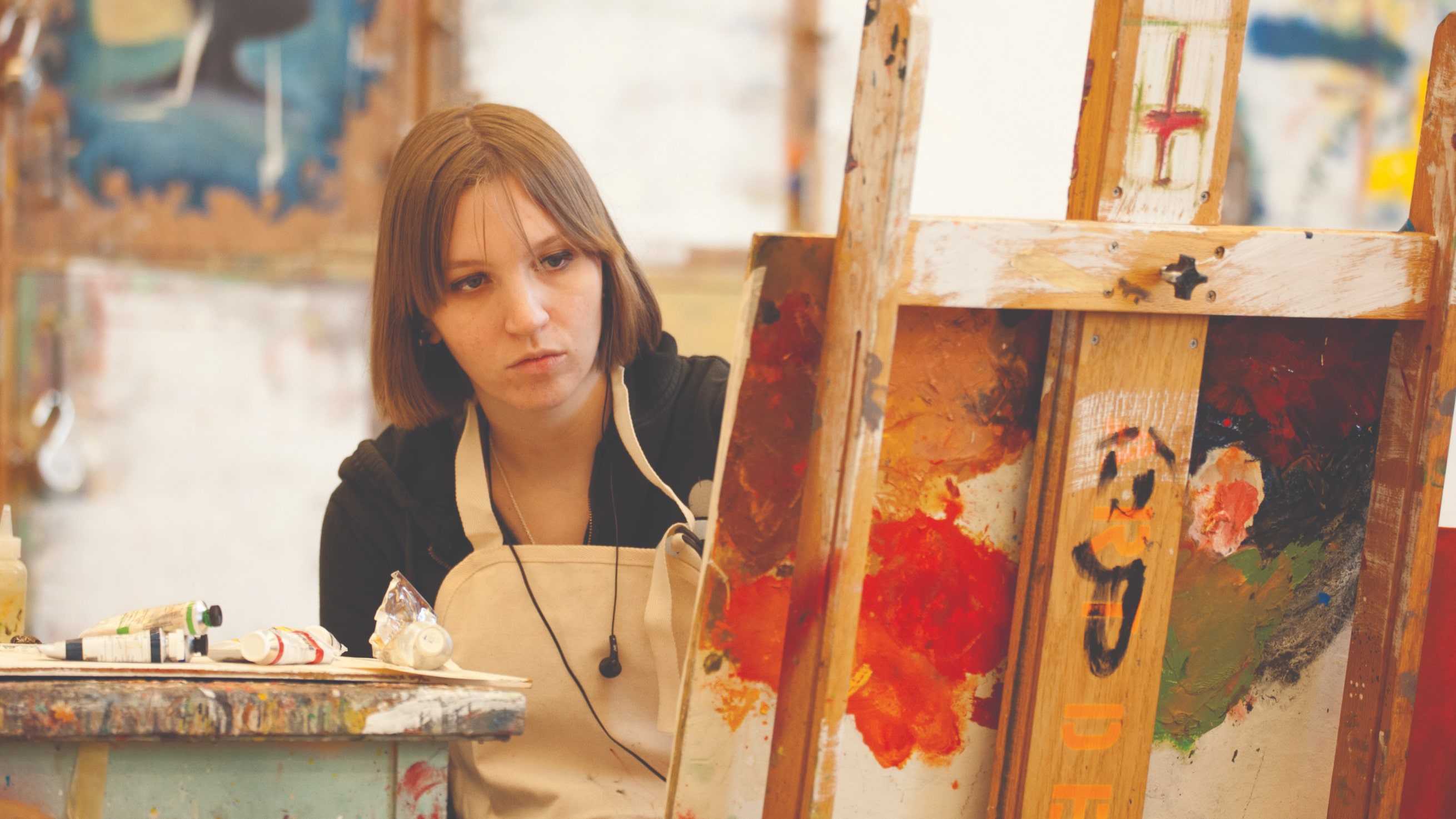 Student painting on an easel