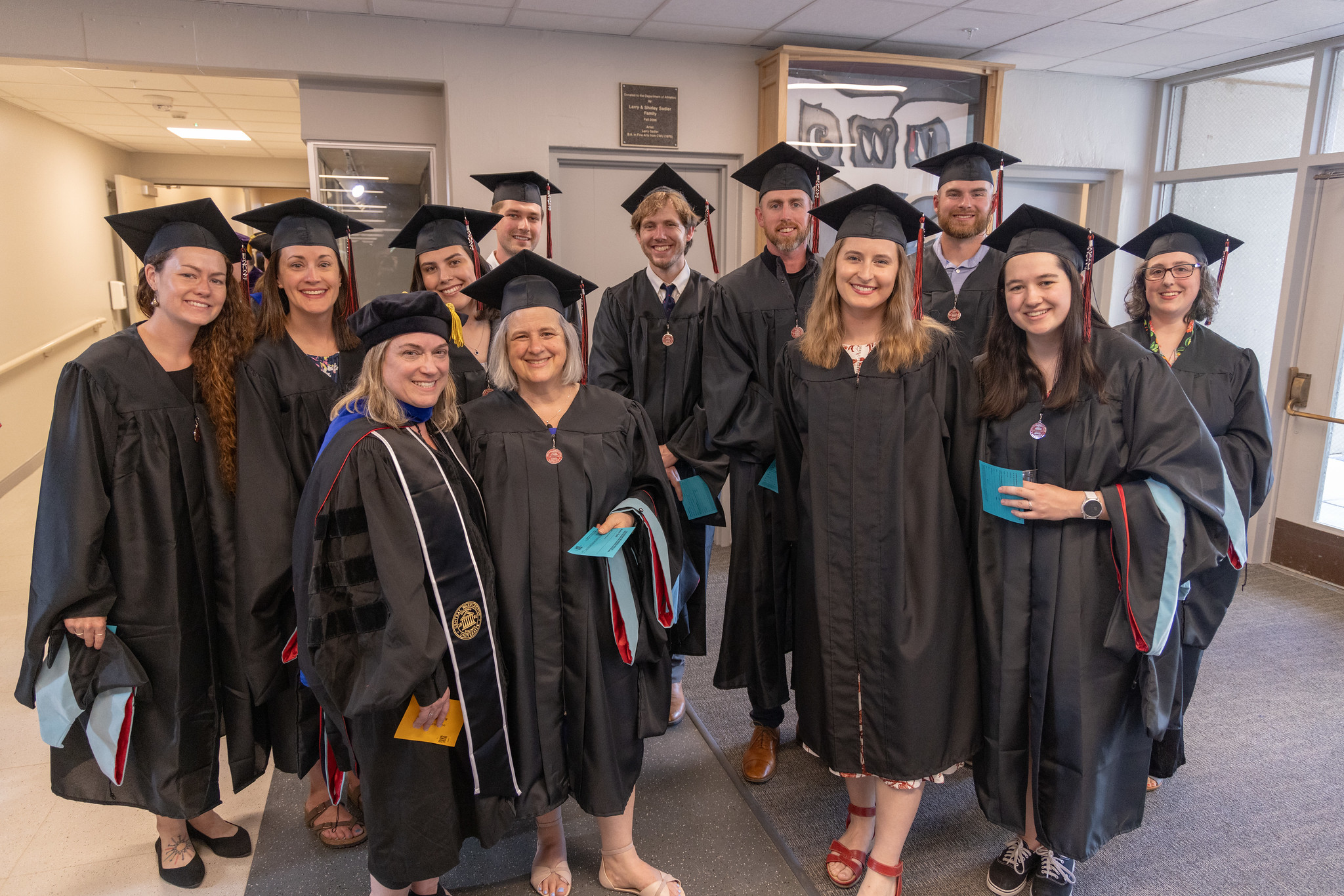 Graduates standing together in a group in their master's regalia