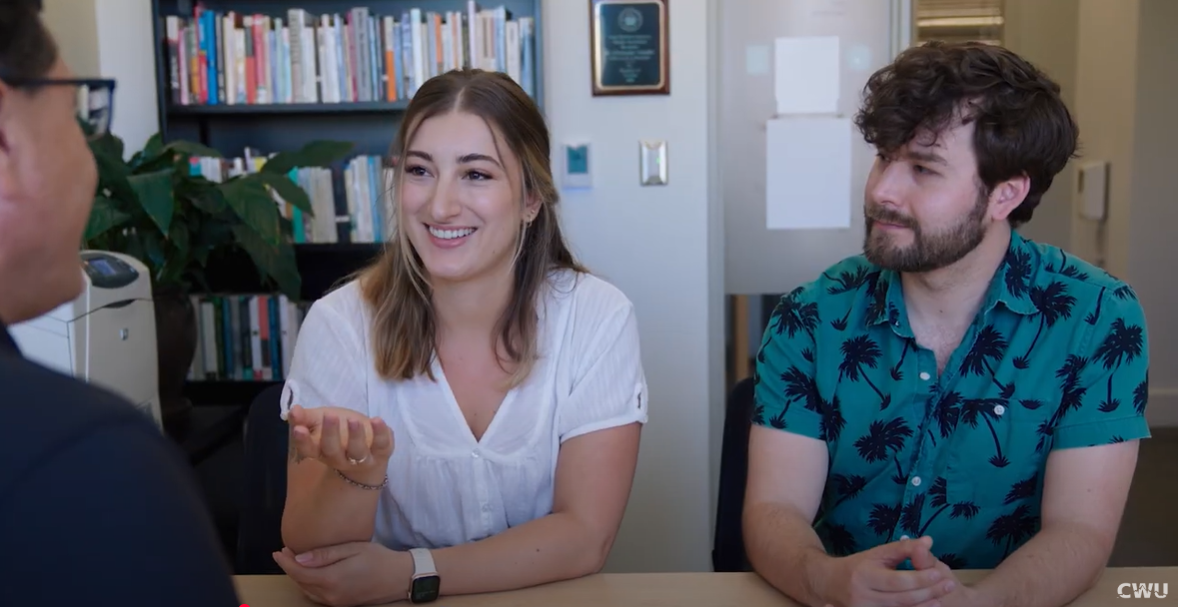 two students talking to a professor