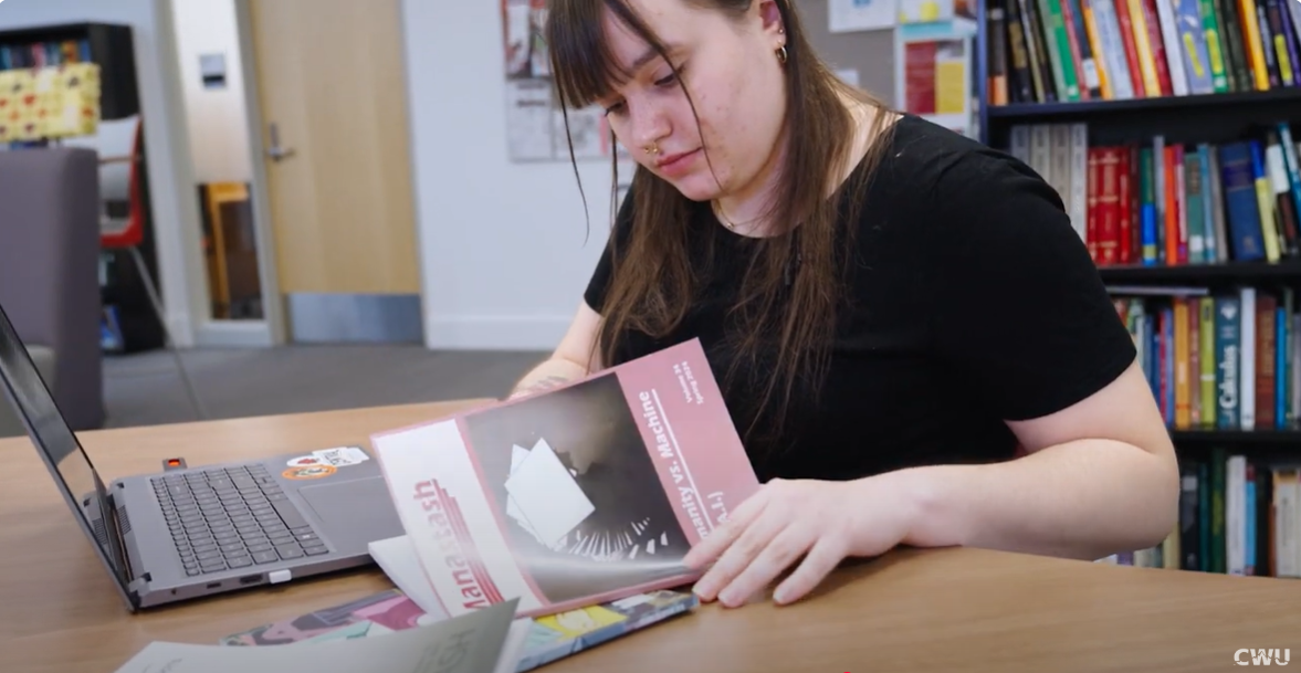 Student looking at a copy of the Manastash publication.