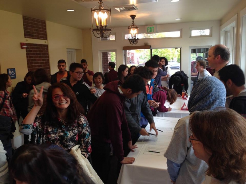 Students and staff crowded around a table.