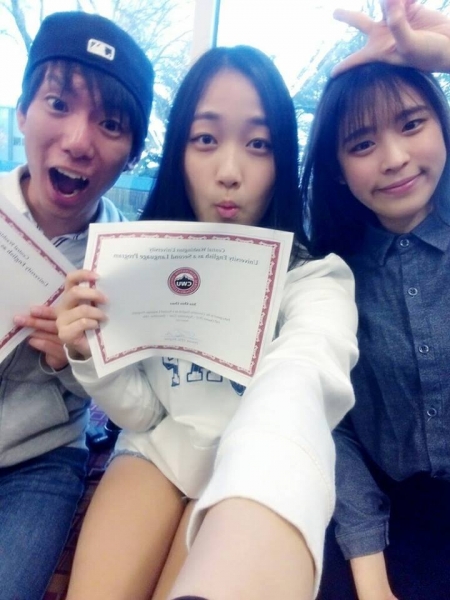 3 students smiling and displaying their certificate.