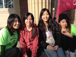 4 students smiling together outside.