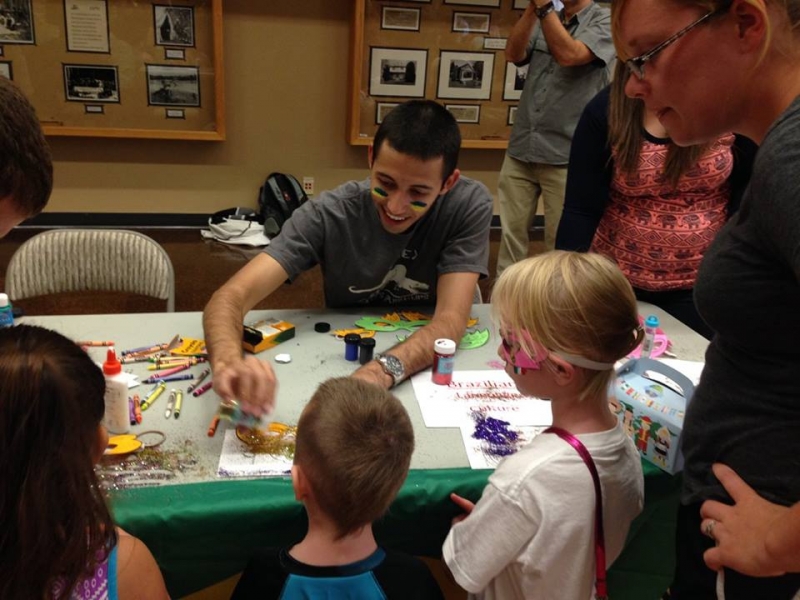 Children and a student crowded around a table.