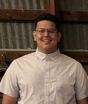 Jesse Higuera smiling in a photo. He's wearing a white button up