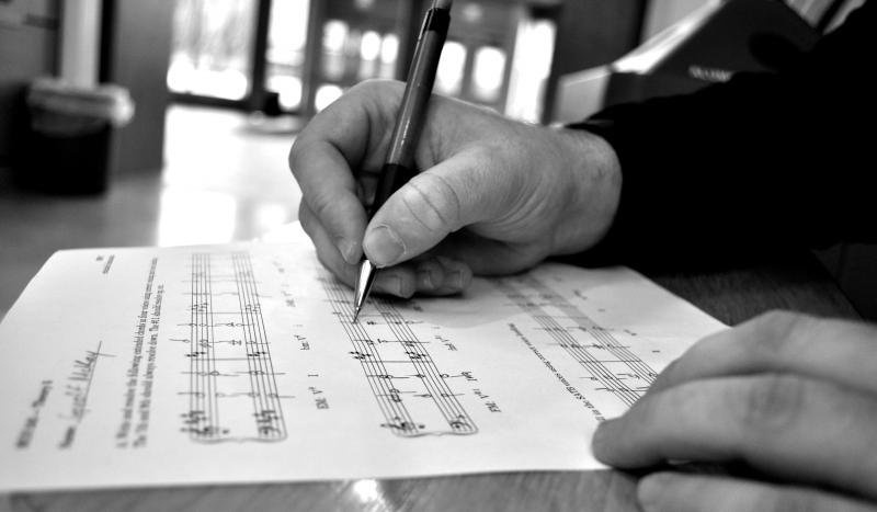 A close up photo of student hand editing a piece of music they composed.