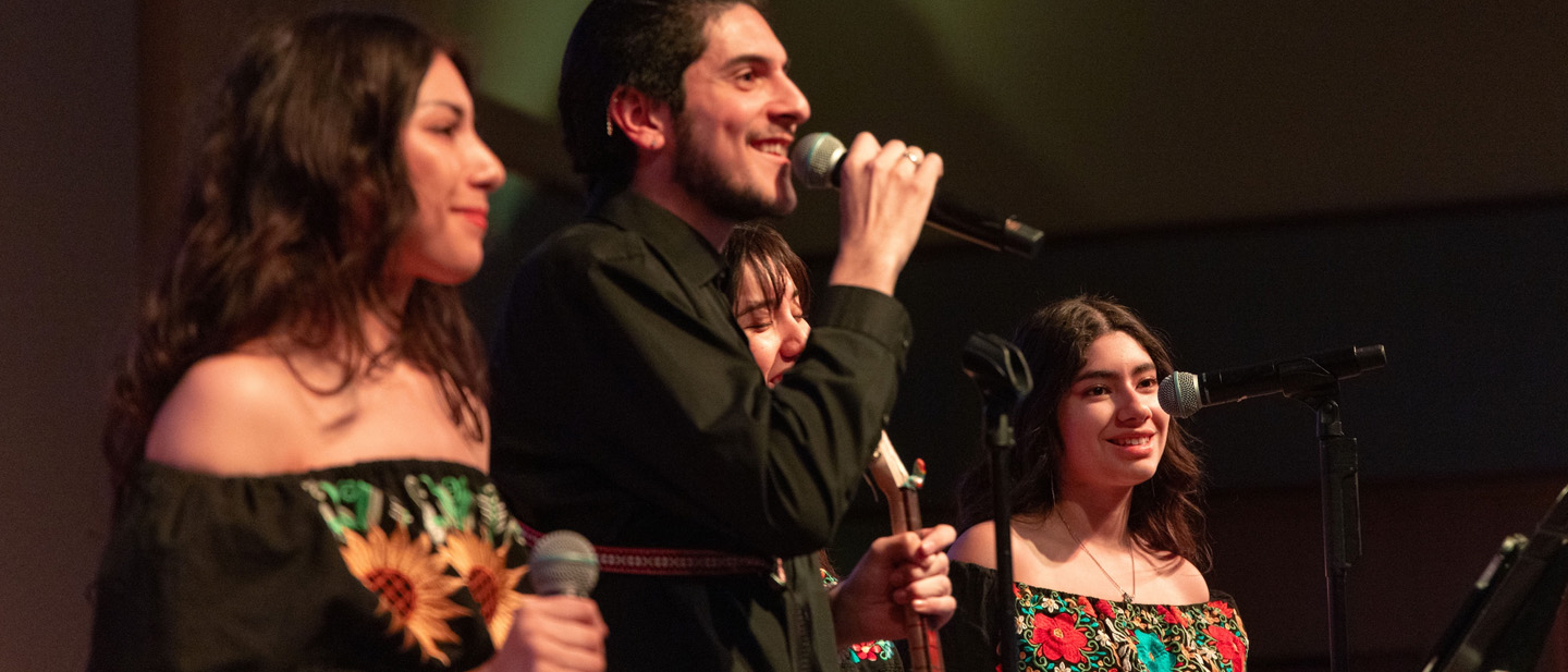 Mariachi ensemble performing on concert hall stage.