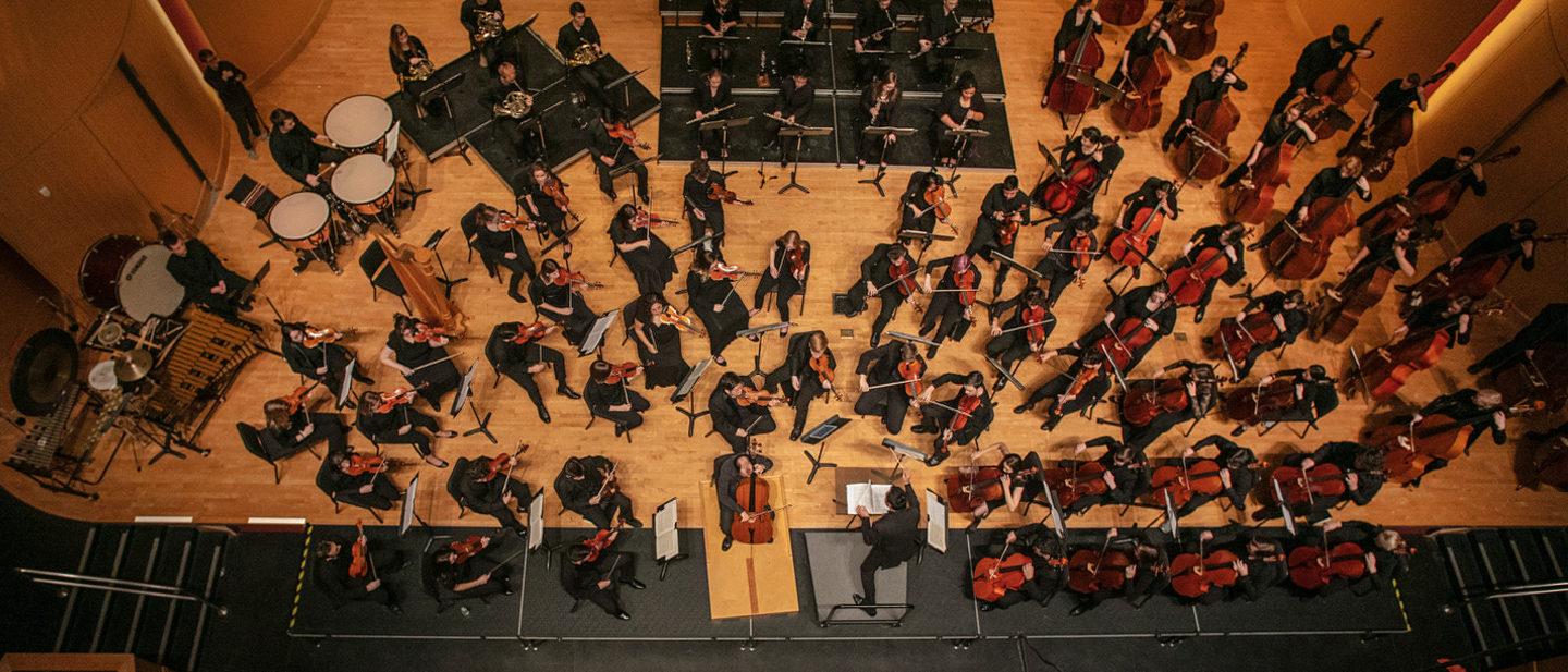 Overhead image of orchestra rehearsing onstage.