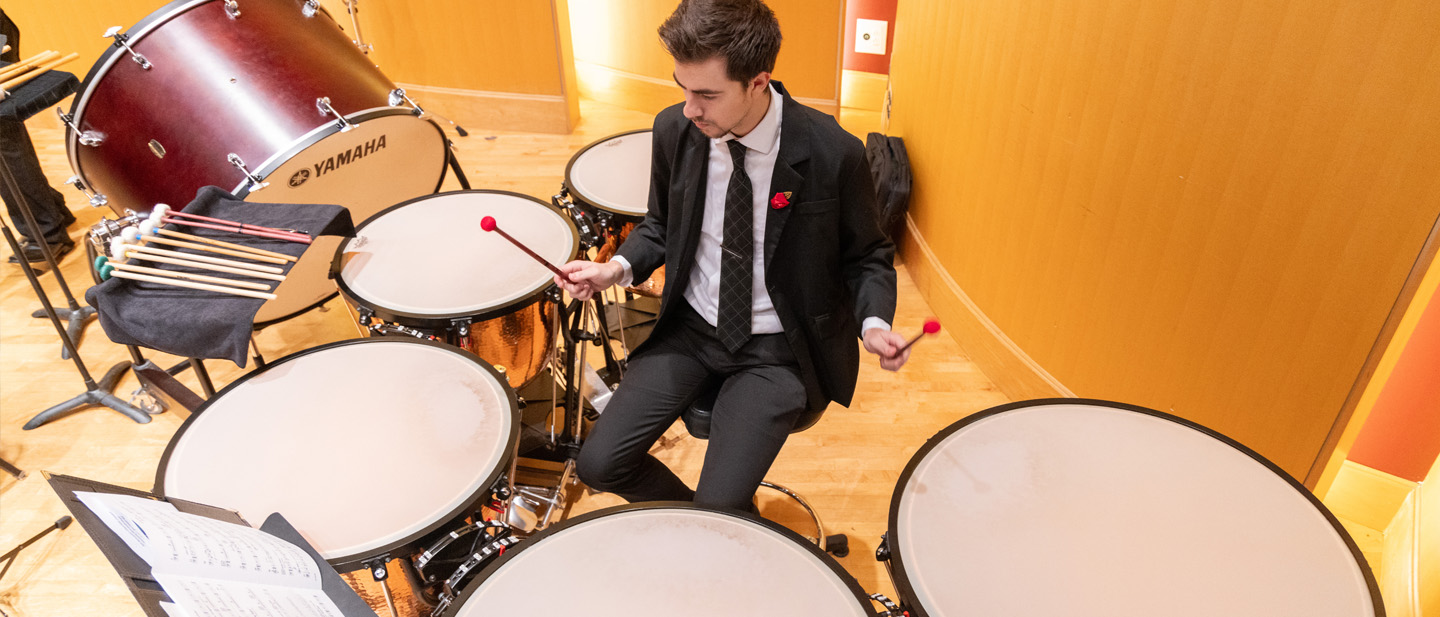 Overhead image of a student playing the timpani drums.