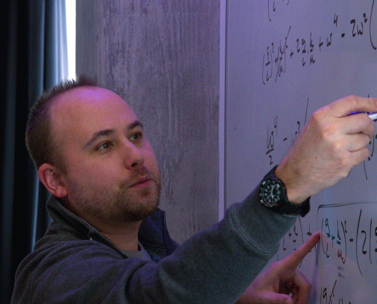 Dr. Kuwada is writing on a whiteboard.