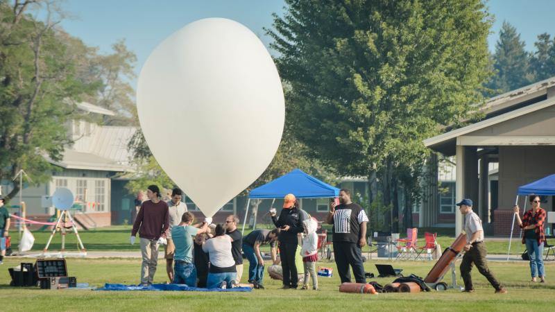 Students preparing to launch a large white balloon with payload during the 2017 solar eclipse.